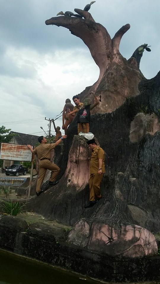 Wakil bupati Kobar, Ahmadi Riansyah dibantu beberapa staf protokol dan komunikasi Setda melepas kaos yang terpasang di salah satu patung orangutan. (Foto Ist)