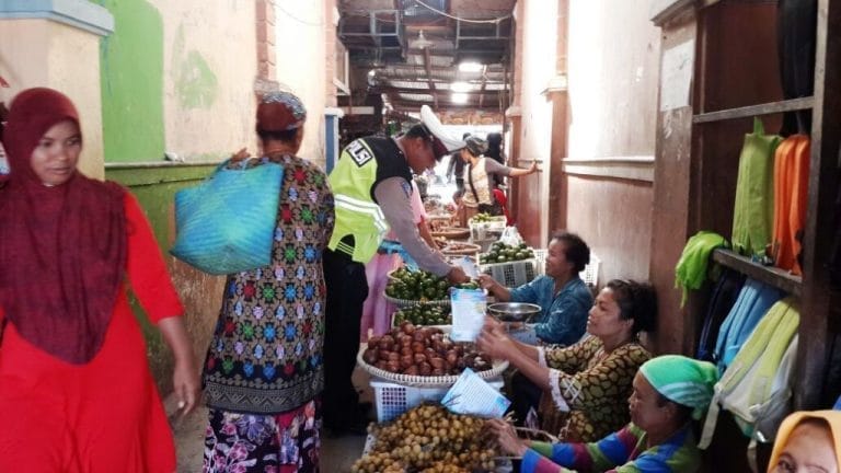 Seorang Polantas Satlantas Polres Kobar tengah memberikan brosur tertib berlalulintas kepada pedagang di Pasar Indrasari