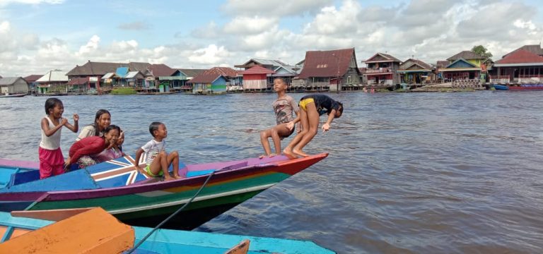 Anak-anak Habiskan Waktu Bermain-main di Sungai Arut Dengan Gembira