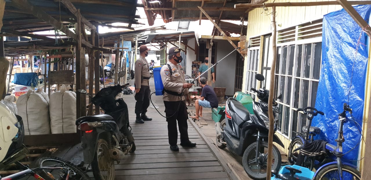 Personel Polsek Maliku Semprot disinfektan di Pasar Mingguan