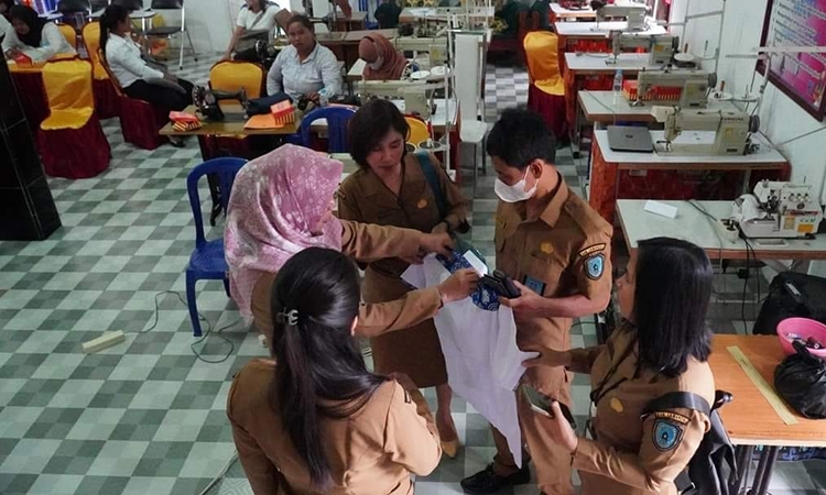kepala disnakertrans atie dieni memeriksa hasil jahitan peserta pelatihan