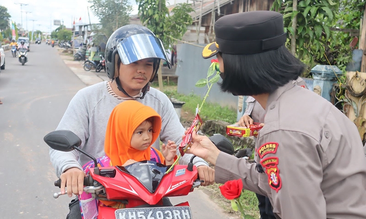 polwan bagikan bunga dan coklat kepada pengguna jalan