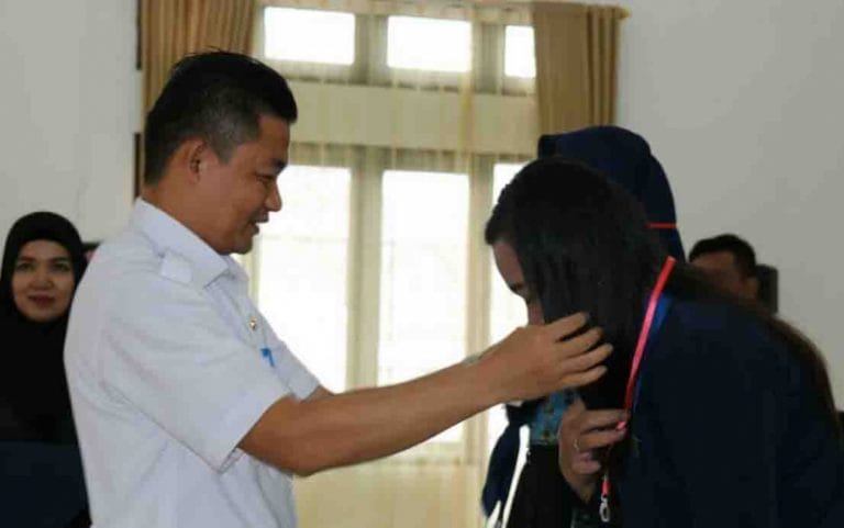 Wabup Lamandau mengalungkan tanda peserta sosialisasi Pemilu 2019 khusus untuk perempuan.